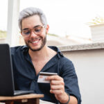 young hipster man holding credit cart using comput 2022 01 18 23 34 37 utc