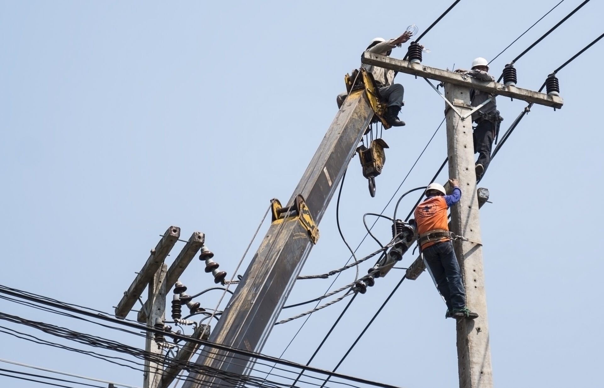 selective focus of electricians are fixing power transmission line on electricity pole