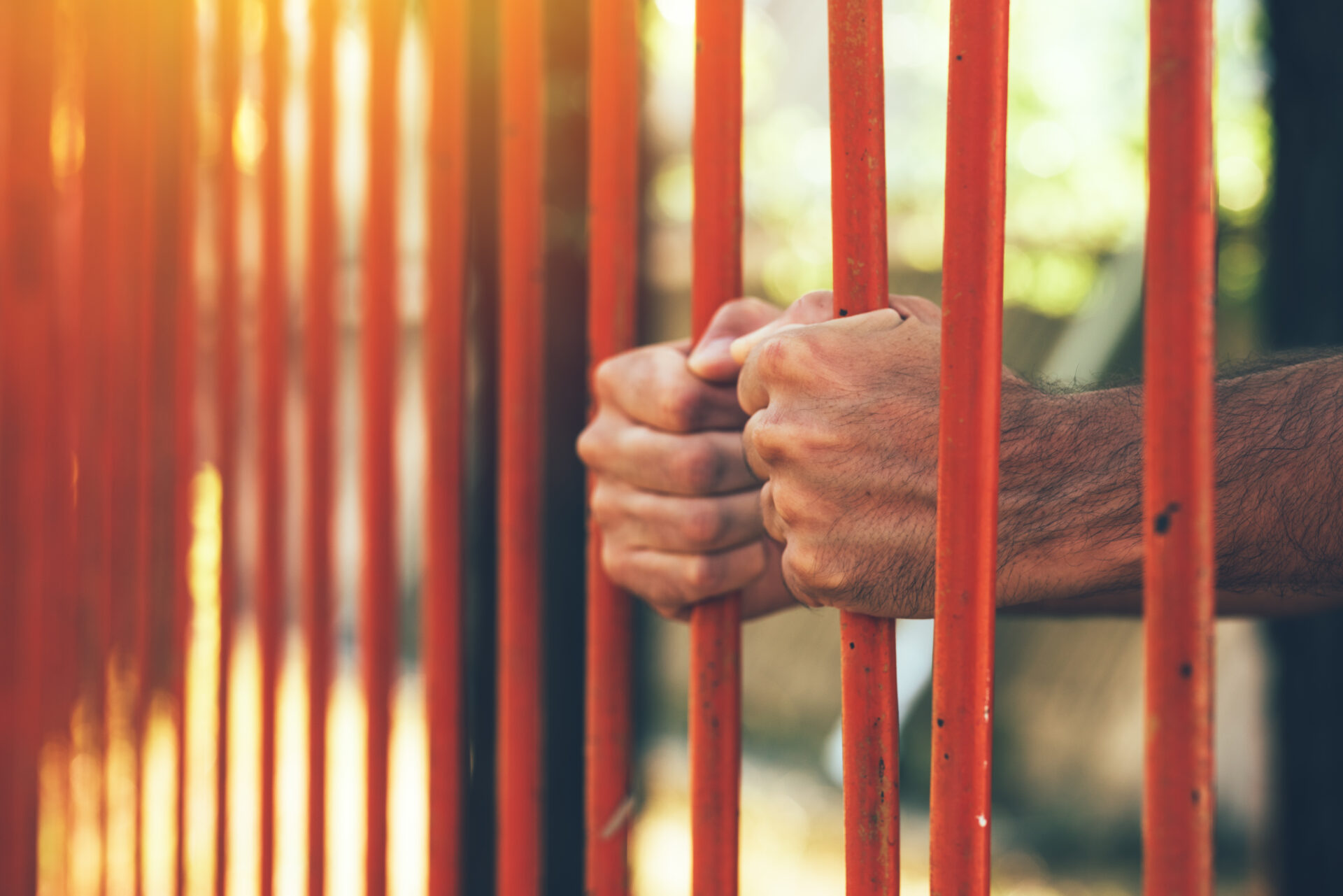 male hands behind prison yard bars 2021 08 26 23 02 46 utc