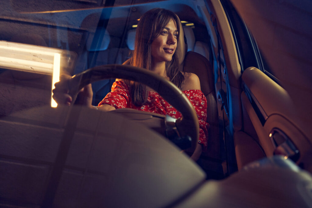joyful young woman driving car at night 2022 01 18 23 45 01 utc
