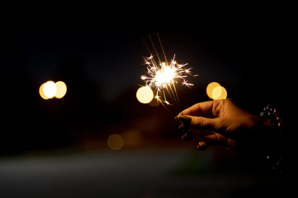 person holding festive sparkler