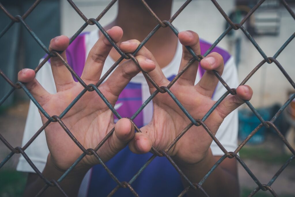asian young boy holding on a metal chain wire mesh 2022 11 08 07 45 45 utc