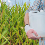 farmer holding pesticide chemical jug in cornfield 2021 08 26 23 03 02 utc