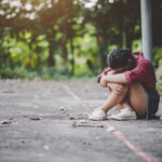 muchacha triste sentada parque