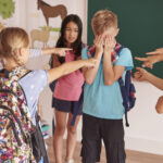 ninos riendose su companero clase