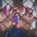 asian young boy holding on a metal chain wire mesh 2022 11 08 07 45 45 utc copia