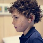 young boy with hearing aid 2022 12 16 00 34 34 utc