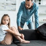 bearded father looking at upset kid sitting on sof 2022 12 16 18 20 10 utc