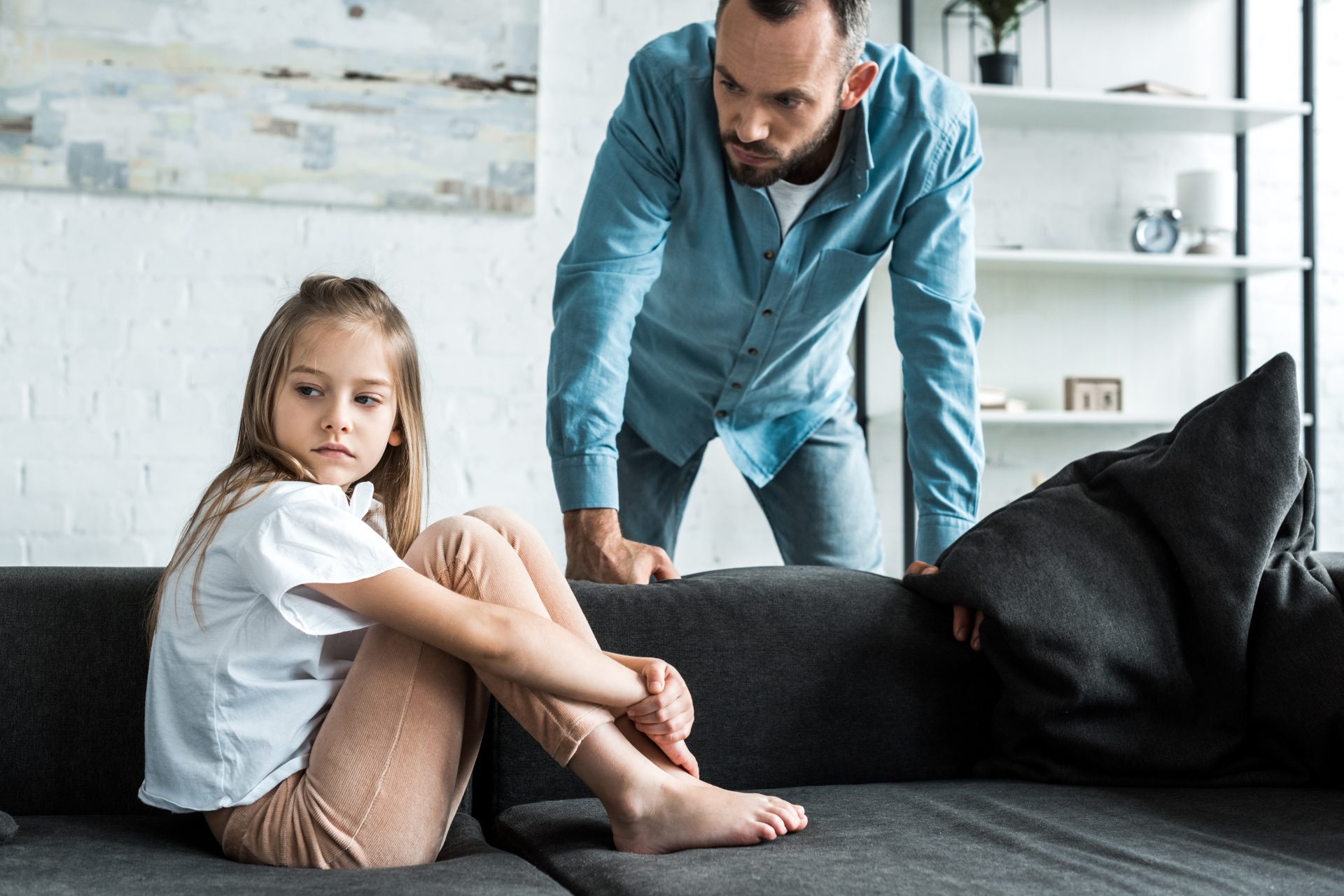 bearded father looking at upset kid sitting on sof 2022 12 16 18 20 10 utc