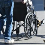 man pushing a female in a wheelchair across paveme 2022 11 14 03 46 06 utc