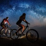 sporty couple riding a bicycles at night under sta 2022 05 10 23 50 33 utc
