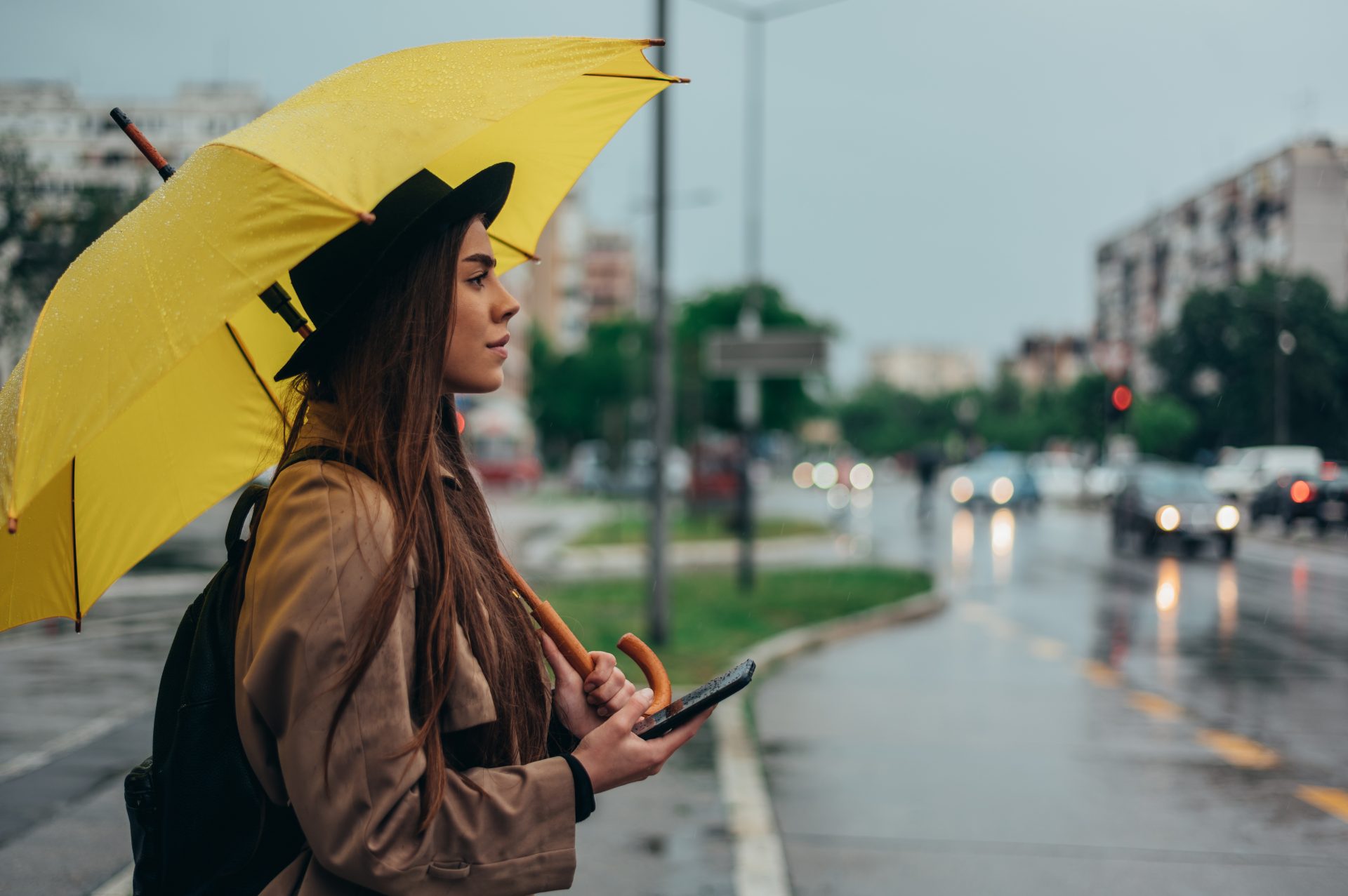 woman using a smartphone and holding yellow umbrel 2022 03 29 07 09 34 utc