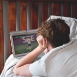 young man laying on bed watching soccer game on la 2022 11 14 06 05 14 utc
