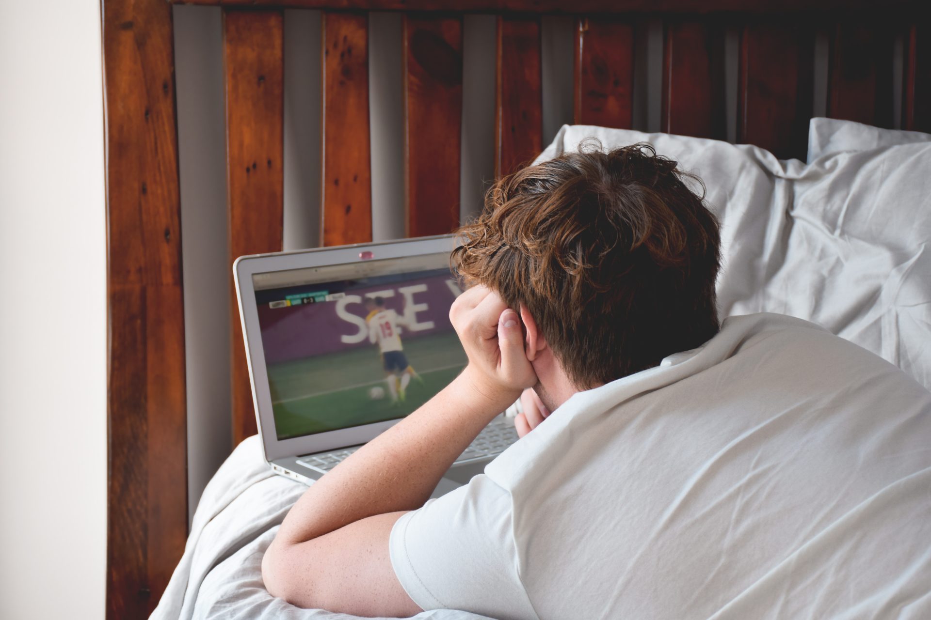 young man laying on bed watching soccer game on la 2022 11 14 06 05 14 utc