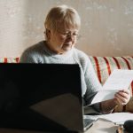 senior woman using laptop and holding documents at 2021 08 30 20 32 15 utc