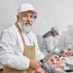 elderly man working on butchery cutting meat with 2021 08 29 23 21 10 utc