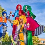 cheerful harlequins on stilts and unicycle in park 2022 11 19 08 13 58 utc