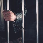 handcuffed man behind prison bars 2021 08 26 23 02 50 utc