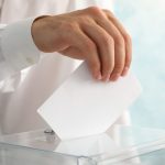 man putting ballot into voting box against blue ba 2021 09 02 22 33 19 utc