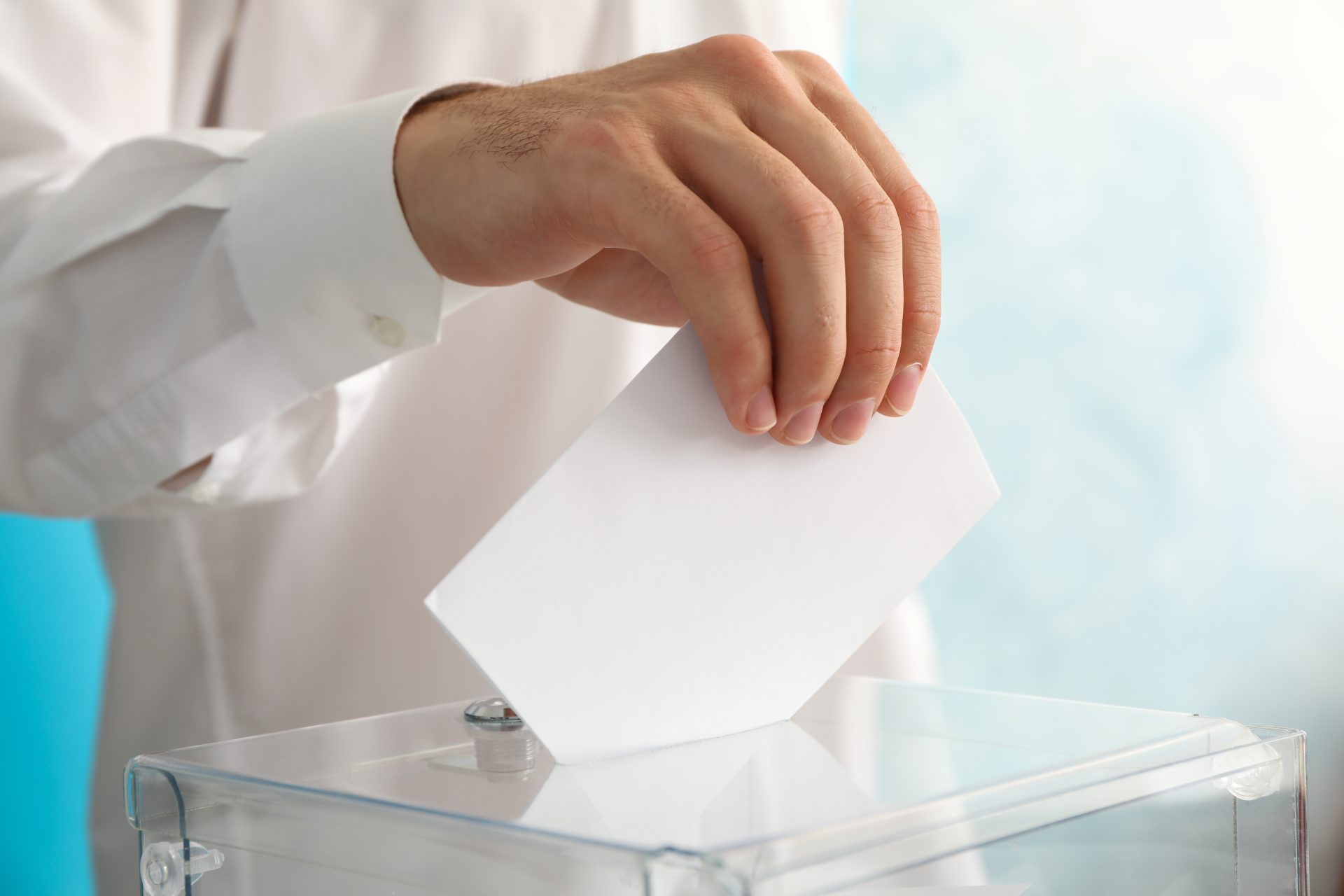 man putting ballot into voting box against blue ba 2021 09 02 22 33 19 utc