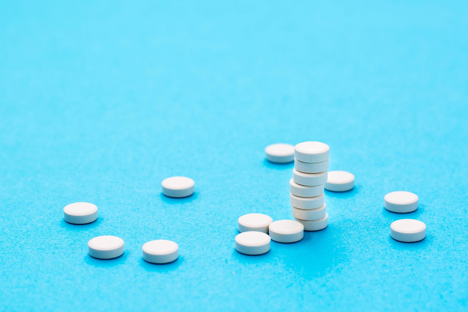 white round pills in a stack and next on a blue ba 2022 06 21 18 11 08 utc
