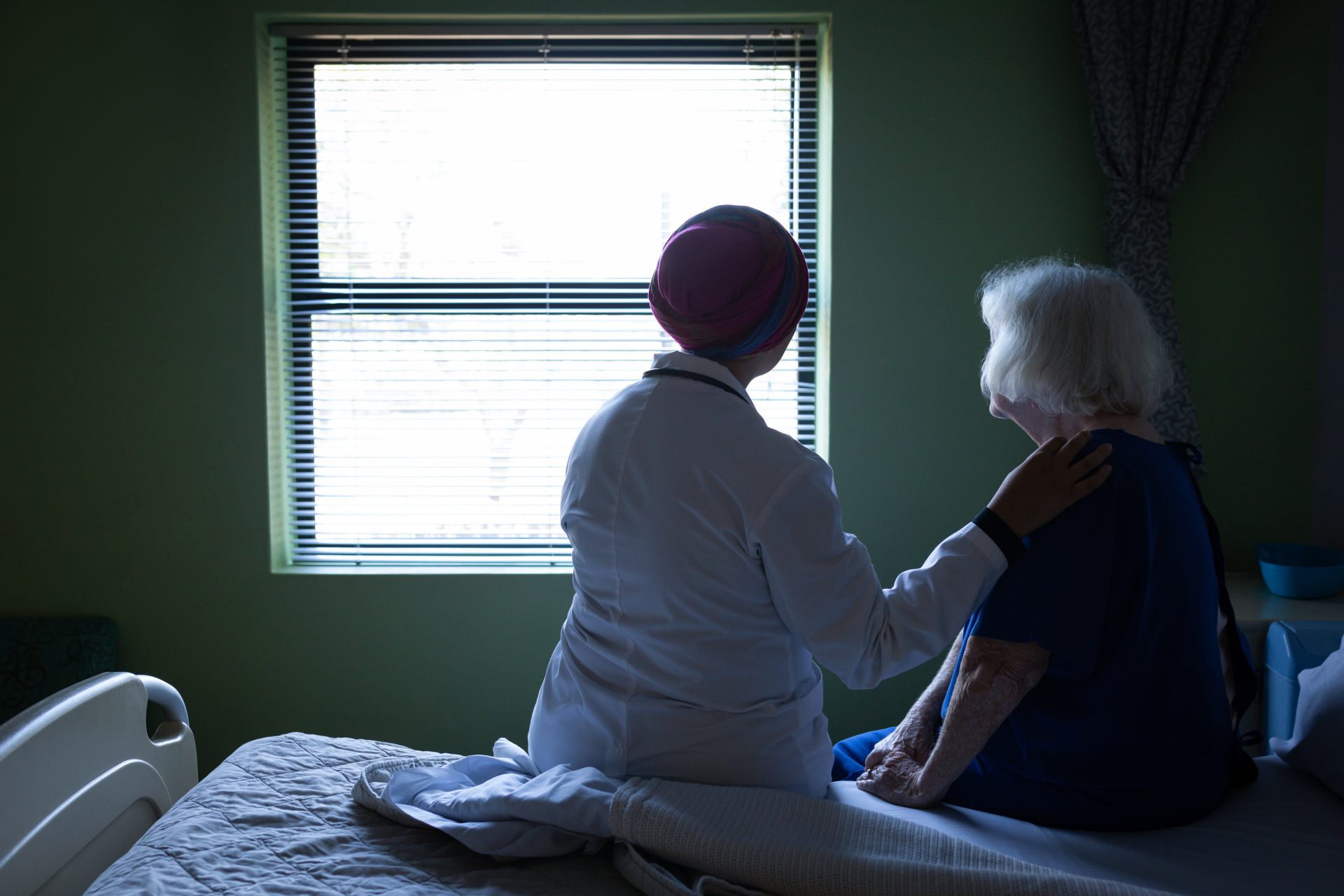 female doctor and senior woman sitting on bed in h 2021 08 28 16 45 41 utc