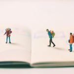 miniature people backpack on passport page with im 2022 11 01 02 39 11 utc