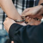police officer puts handcuffs on a car thief 2021 08 26 16 26 45 utc