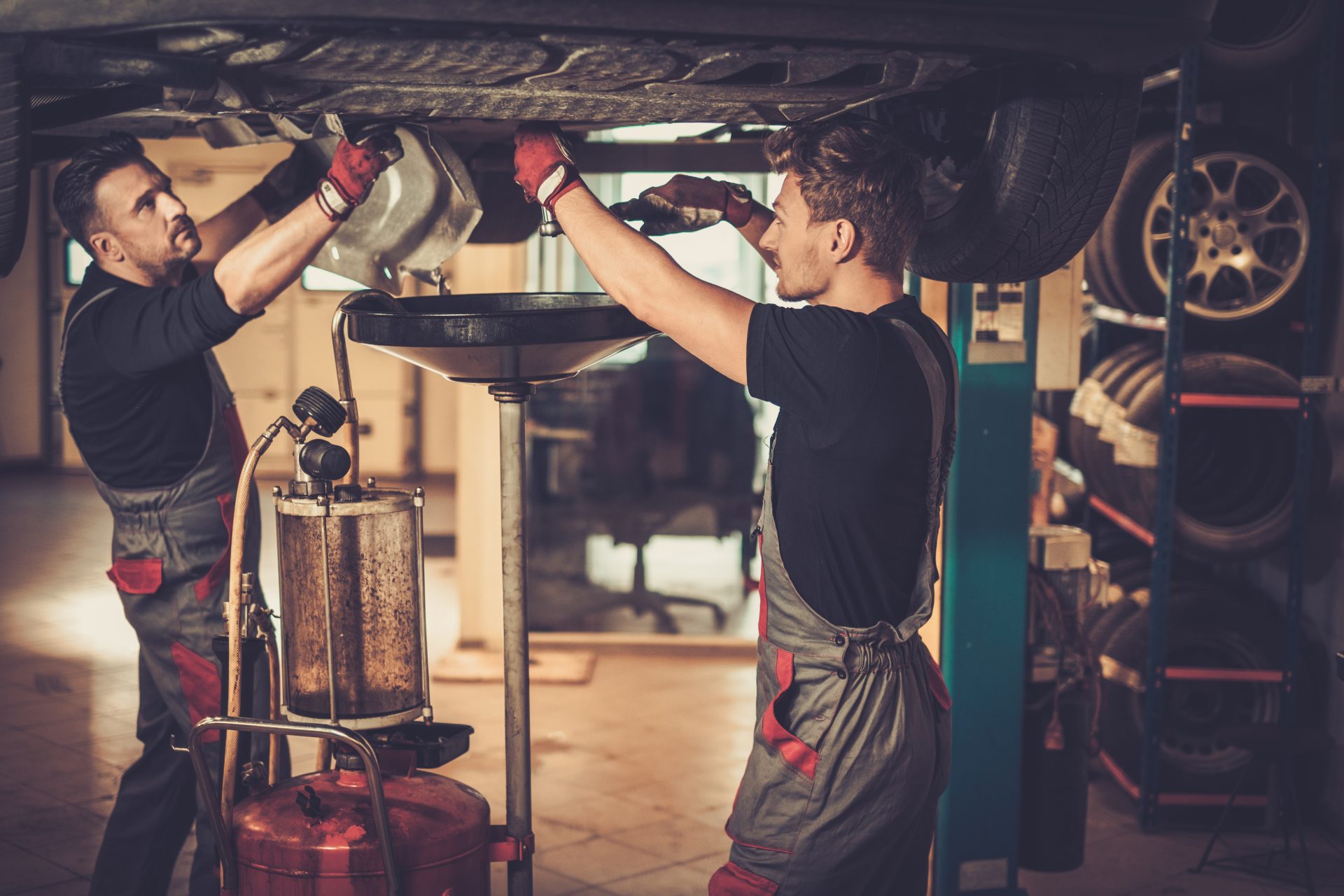 professional car mechanic changing motor oil in a 2021 08 26 16 21 11 utc