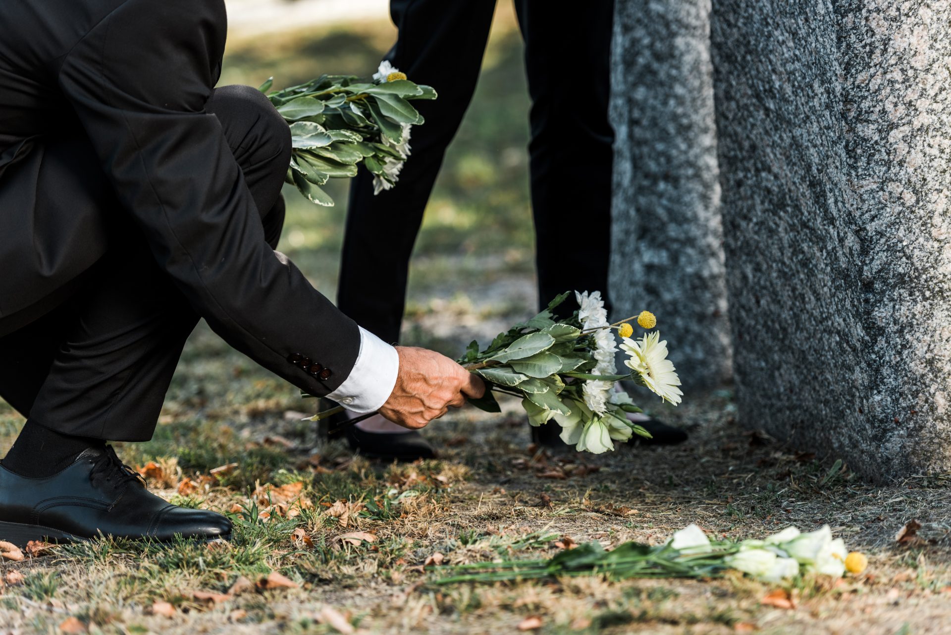 cropped view of senior man putting flowers near to 2022 12 16 20 42 42 utc