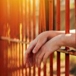 female hands behind prison yard bars 2021 08 26 23 02 47 utc