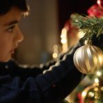 kid putting christmas ball on the tree 2023 11 09 11 13 19 utc