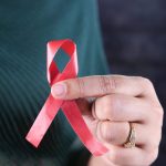women hand holding red hiv ribbon isolated on blac 2023 11 27 05 18 59 utc