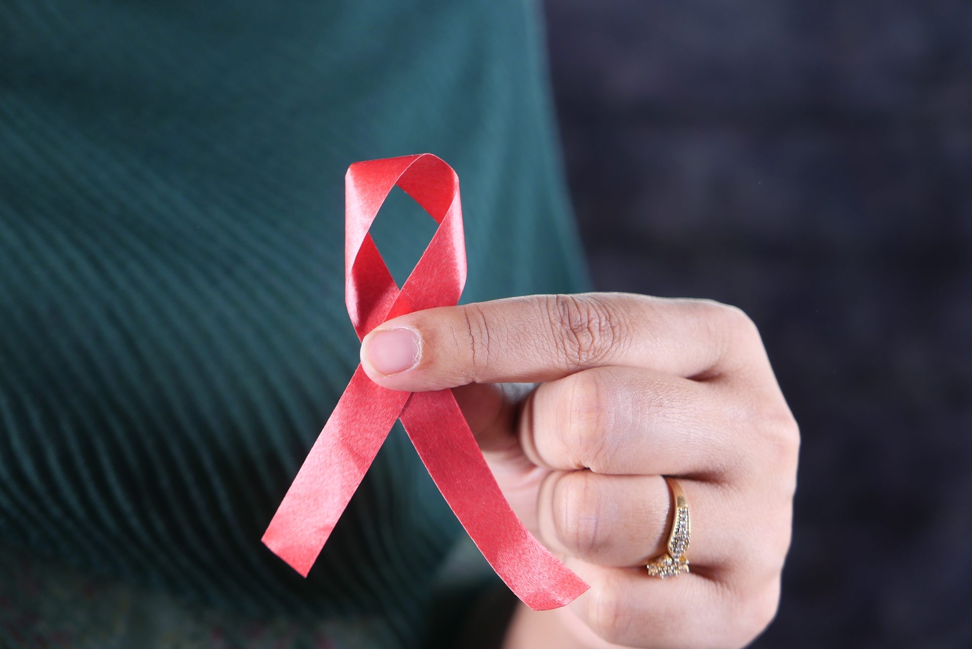 women hand holding red hiv ribbon isolated on blac 2023 11 27 05 18 59 utc