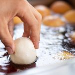 hand dropping flour into oil for frying preparing 2023 11 27 05 23 23 utc