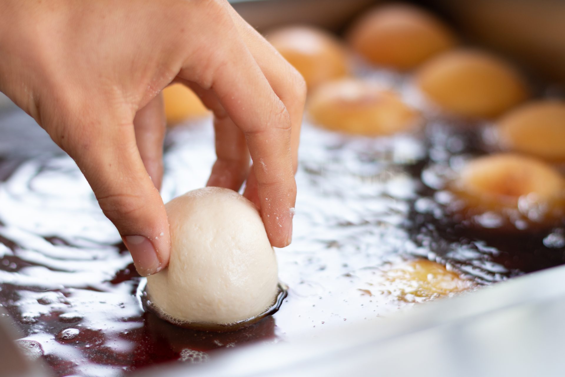 hand dropping flour into oil for frying preparing 2023 11 27 05 23 23 utc