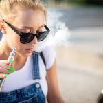 modern woman outdoor smoking e cigarette while sit 2023 11 27 05 01 53 utc