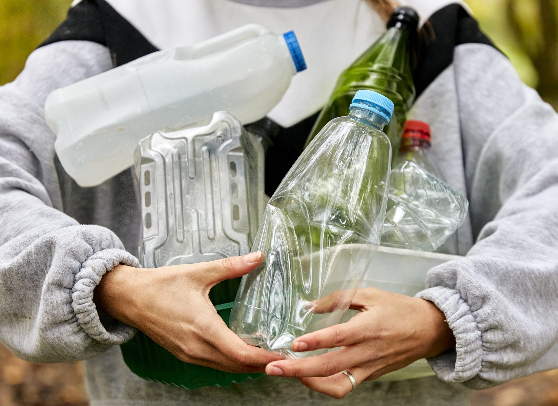 woman holding armful of various used plastic items 2023 11 27 05 02 28 utc