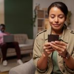 african young woman watching something her mobile phone with man