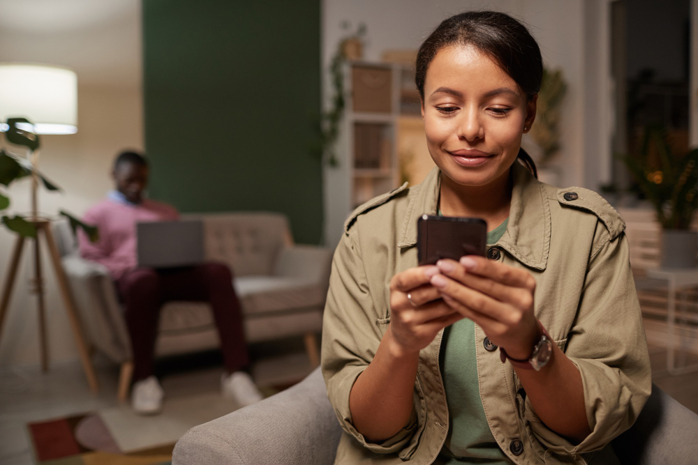 african young woman watching something her mobile phone with man