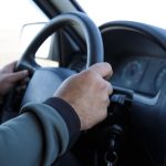 man s hands hold steering wheel driving a vehicle 2023 11 27 05 07 10 utc
