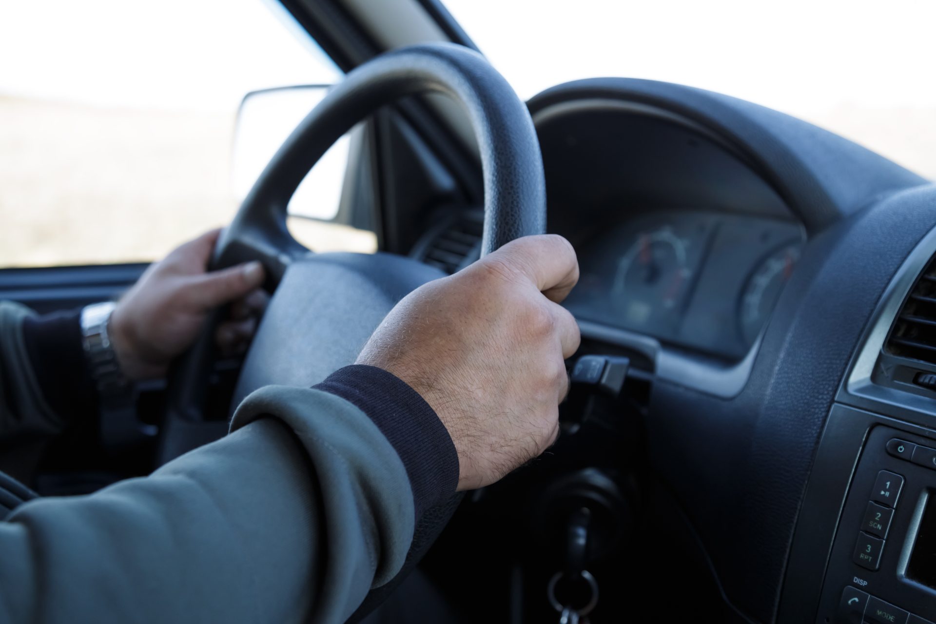 man s hands hold steering wheel driving a vehicle 2023 11 27 05 07 10 utc