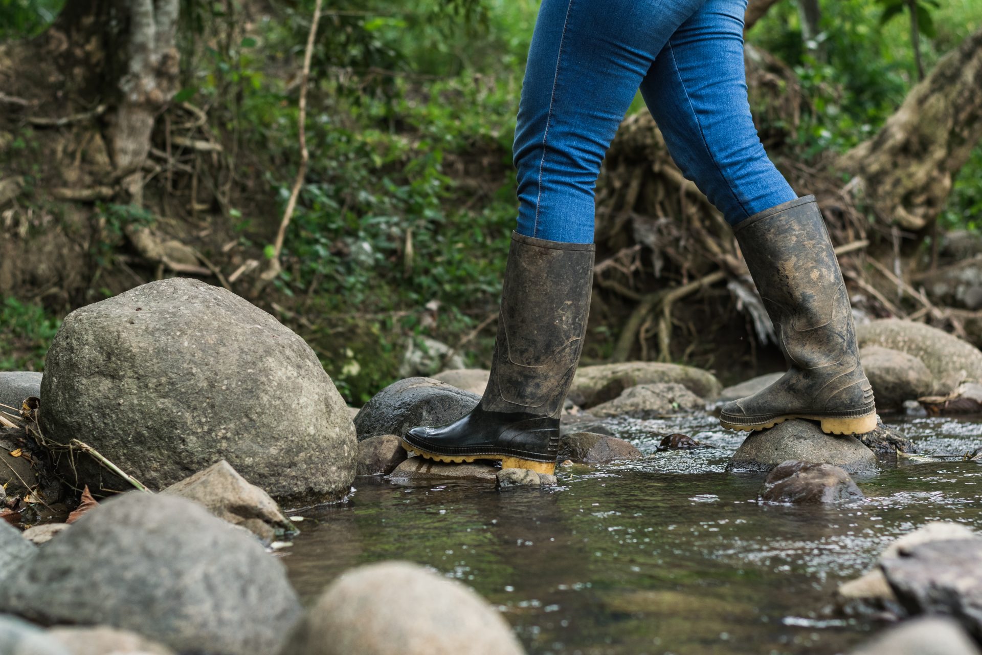 migrant woman crossing a stream wearing blue jeans 2023 11 27 05 12 13 utc