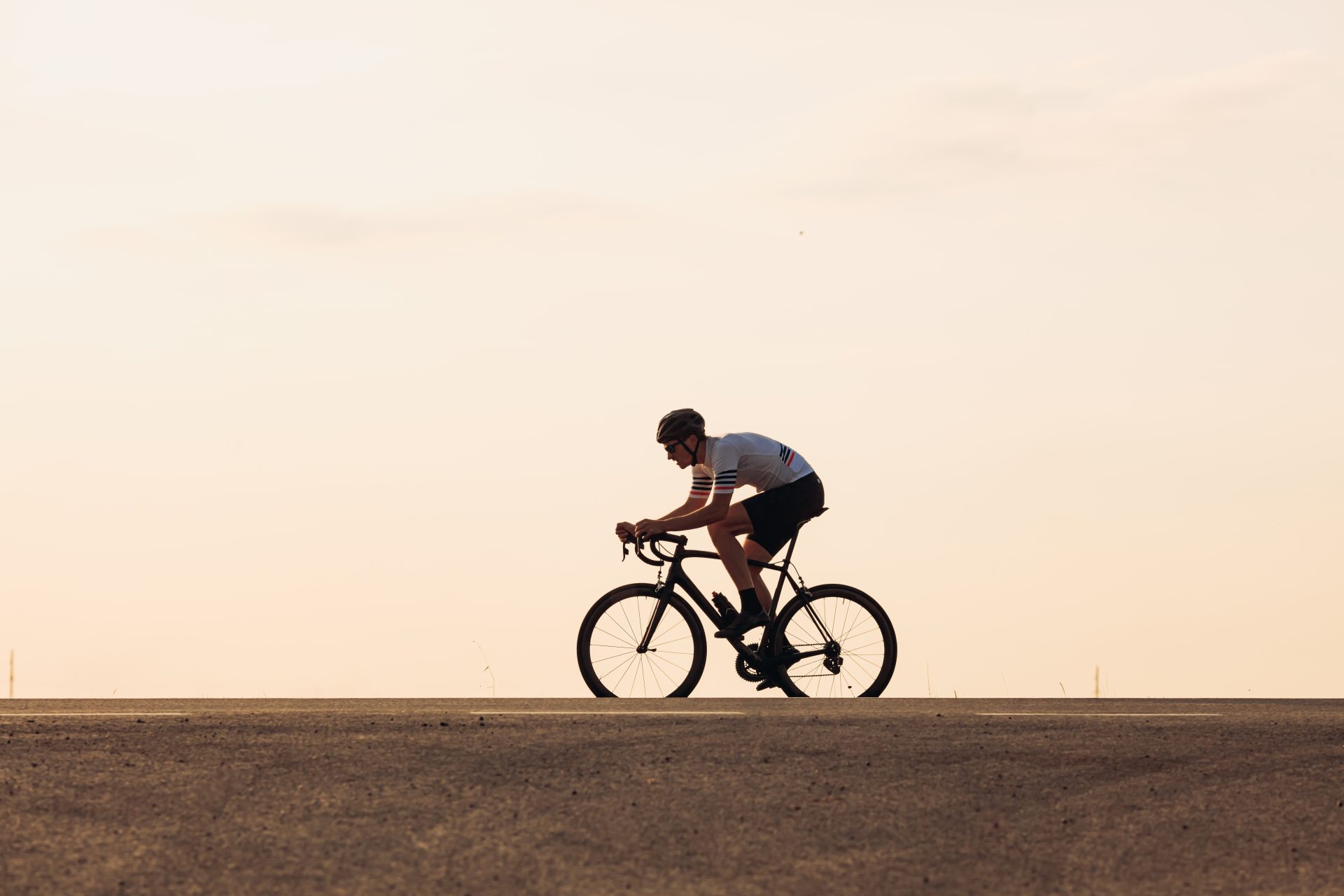 muscular athlete in helmet cycling on asphalt road 2023 11 27 05 35 21 utc