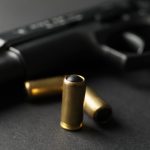 pistol and traumatic bullets on black background 2023 11 27 05 30 03 utc