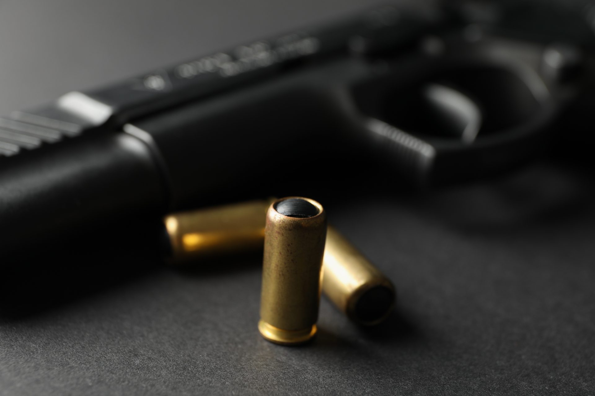 pistol and traumatic bullets on black background 2023 11 27 05 30 03 utc