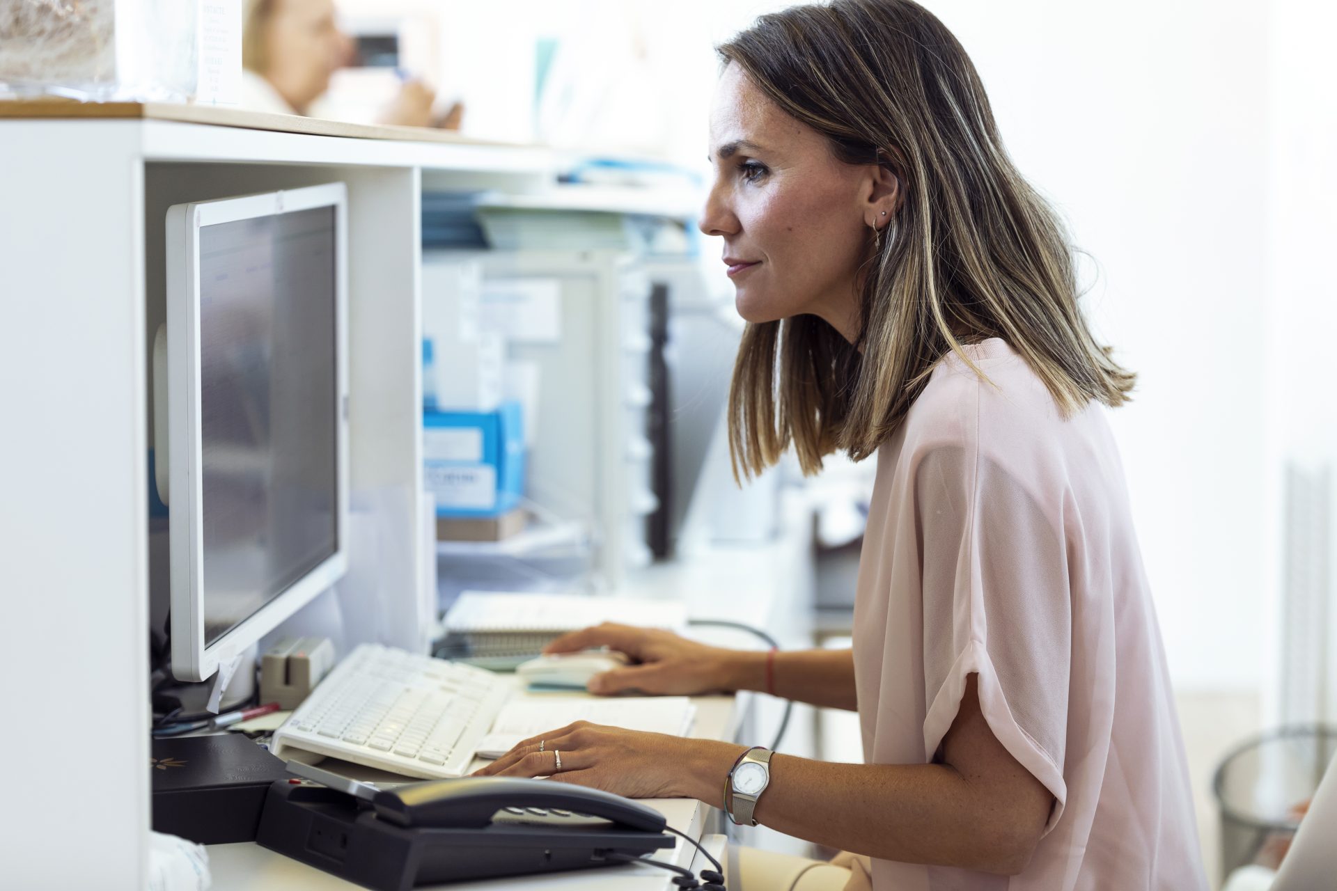 woman working on computer at reception desk 2023 11 27 05 09 12 utc