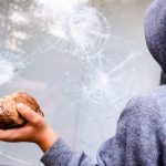 child holds a stone to throw it against a glass an 2023 11 27 04 49 07 utc