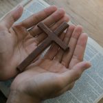 christian man holding jesus cross hands folded in 2023 11 27 04 59 56 utc