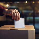 person deposits voting card into ballot box at vot 2024 01 09 18 45 57 utc
